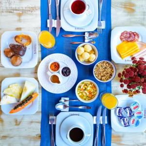 uma mesa azul com pratos e tigelas de comida em Kalango Hotel Boutique em Ilhabela