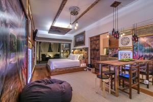 a bedroom with a bed and a desk and a table at epicenter URBAN in Ponta Delgada