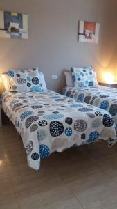 a bedroom with two beds with blue and white sheets at Departamento Joelle in Puerto del Carmen