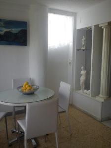 un comedor con mesa, sillas y un bol de fruta en Apartamento Valeria para 14 personas, en Benidorm