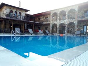 
a swimming pool with a pool table and chairs at Monastiri Guesthouse in Kalabaka
