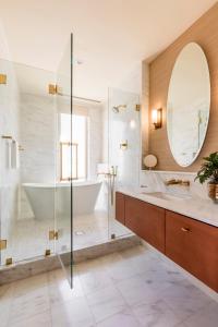 a bathroom with a tub, sink and mirror at The Dewberry Charleston in Charleston