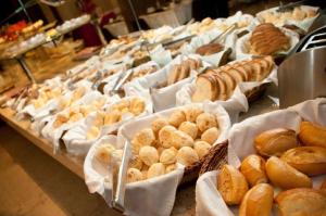 a buffet with many different types of bread and pastries at JB Palace Hotel in Divinópolis