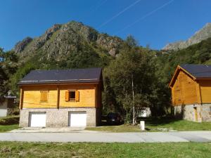 a wooden house with a mountain in the background at Chalet bois au milieu des Pyrénées in Soldeu lʼHospitalet