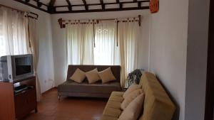 sala de estar con sofá y TV en Cabañas Sol y Luna, en Villa de Leyva