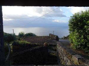 una pared de piedra con vistas al océano en Casa do Bernardo, en Feiteira