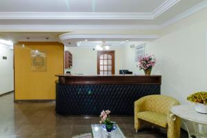 a lobby with a reception desk and a chair at Hotel Acacia in São Caetano do Sul