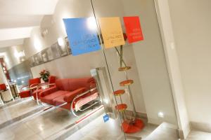 una sala de espera con sillas rojas y carteles en la pared en Hotel & Depandance Kopacka en Lanškroun