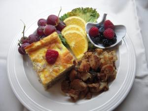 a plate of food with breakfast foods and fruit at Brookview Manor Inn in Canadensis