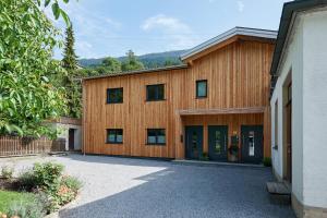 ein Holzhaus mit einer Einfahrt davor in der Unterkunft FEWO Hilbrand Dalaas in Dalaas