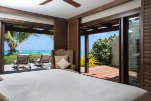 Te Manava Luxury Villas & Spa في راروتونغا: غرفة نوم مع سرير وإطلالة على المحيط