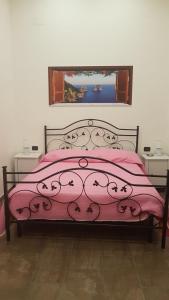 ナポリにあるLe Perle di Napoliのピンクの掛け布団と窓が備わる客室です。