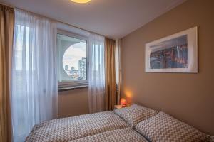 a bedroom with a bed and a window at City On Foot in Wrocław