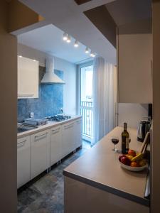 a kitchen with white cabinets and a bowl of fruit on a counter at City On Foot in Wrocław