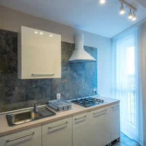 a kitchen with a sink and a stove top oven at City On Foot in Wrocław