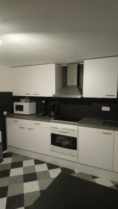 a kitchen with white appliances and a checkered floor at Ferienwohnung er Loof in Monschau