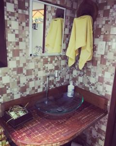 ein Bad mit einem Waschbecken und einem Spiegel in der Unterkunft Suíte Cravo & Canela in São Pedro da Serra