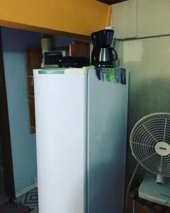 einen Kühlschrank mit einer Kaffeekanne darüber in der Unterkunft Suíte Cravo & Canela in São Pedro da Serra