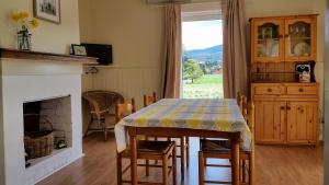 a dining room with a table and a fireplace at The Manager's Cottage in Grove