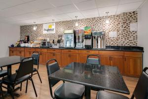 a restaurant with a table and chairs and a counter at Twin Cities Inn, Mounds View in Mounds View