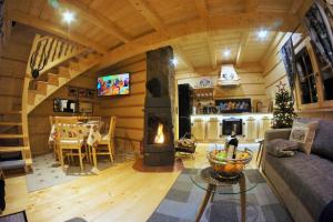 - un salon avec une cheminée dans une maison dans l'établissement Góralska Osada Karpacz - Domki Lux, à Karpacz