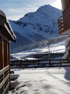 une vue d'une montagne enneigée avec une clôture dans l'établissement Apartment Le Logge, à Sestrières