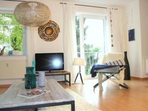 een woonkamer met een televisie en een tafel bij Exklusive Ferienwohnung an der Elbe in Dresden