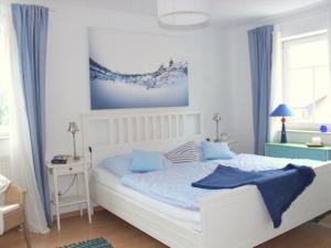 een slaapkamer met een groot wit bed met blauwe kussens bij Exklusive Ferienwohnung an der Elbe in Dresden