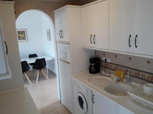 ネルハにあるCasa Bosquesの白いキャビネットとシンク付きのキッチン