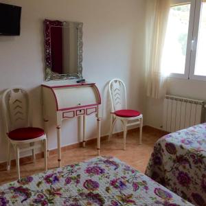een slaapkamer met een kaptafel met een spiegel en 2 stoelen bij Complejo Ribera de Salobre in Salobre