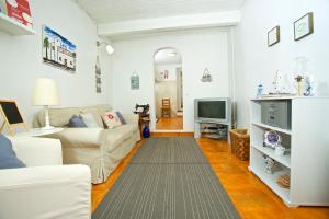 a living room with a couch and a television at Casinha da Aldeia in Melides