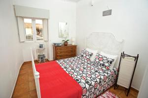 a bedroom with a large bed with a red blanket at Casinha da Aldeia in Melides