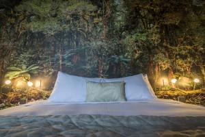 Una cama en un bosque con luces. en The Cinema Suites, en Te Anau