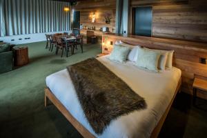 a bedroom with a large bed with a faux fur blanket at The Cinema Suites in Te Anau