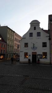 un edificio blanco en una calle con edificios en Apartament Bartolomeo en Toruń