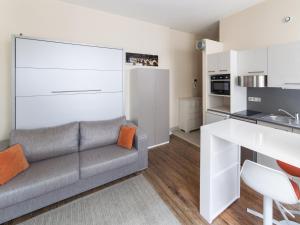 een woonkamer met een bank en een keuken bij Studio triangle d'Or in Bordeaux