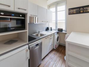 uma cozinha branca com um lavatório e um micro-ondas em Studio triangle d'Or em Bordeaux