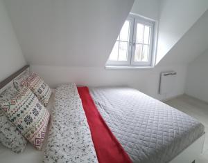 sypialnia z łóżkiem z poduszkami i oknem w obiekcie Wysokie Łąki domki w górach w mieście Kowary
