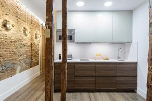 kuchnia z drewnianymi szafkami i ceglaną ścianą w obiekcie Madrid Center, Apartamento de 2 dormitorios w Madrycie