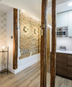 kuchnia z ceglaną ścianą i drewnianymi belkami stropowymi w obiekcie Madrid Center, Apartamento de 2 dormitorios w Madrycie