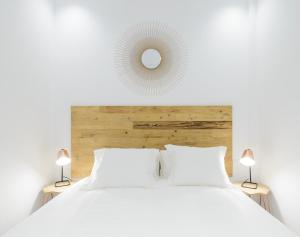 biała sypialnia z białym łóżkiem i lustrem w obiekcie Madrid Center, Apartamento de 2 dormitorios w Madrycie
