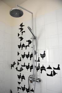 a shower in a bathroom with black fish on the wall at Le Rondinelle in Como