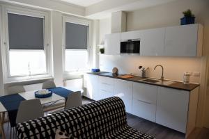 a kitchen with white cabinets and a table and a dining room at Le Rondinelle in Como