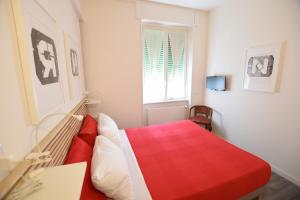 a bedroom with a red bed and a window at Le Rondinelle in Como