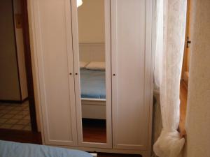 a closet with a mirror and a bed in a room at Mirtilli in Prato Nevoso