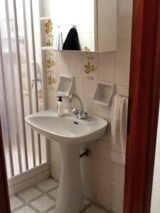 a bathroom with a white sink and a mirror at Mirtilli in Prato Nevoso