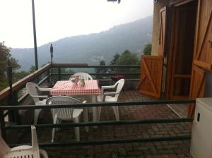un tavolo e sedie sul balcone di una casa di Mirtilli a Prato Nevoso