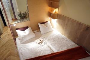 sypialnia z łóżkiem z białymi prześcieradłami i poduszkami w obiekcie WANZ'inn Design Appartements w Wiedniu