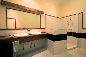 a bathroom with two sinks and a large mirror at Tawali Leisure & Dive Resort in Alotau