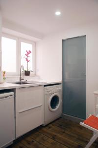 eine Küche mit einer Waschmaschine und einem Waschbecken in der Unterkunft Chiado/Carmo Apartment in Lissabon